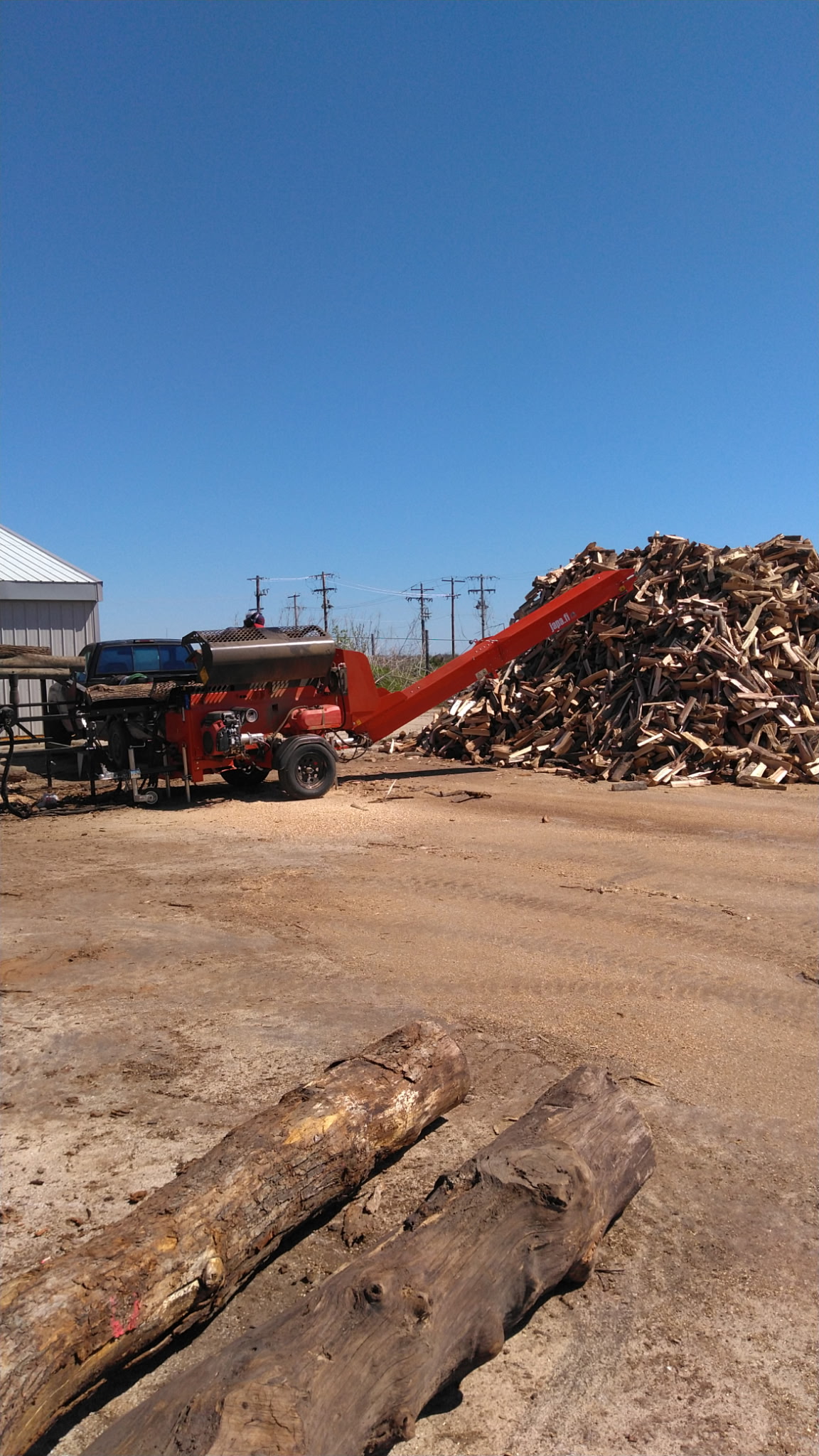 Loading freshly processed firewood onto the pile